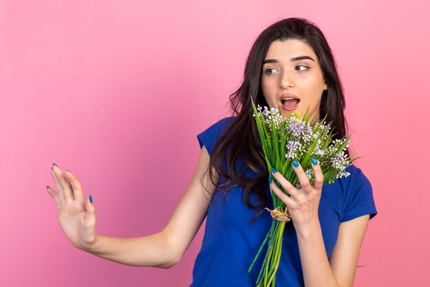 Young lady holding flowers and gesture stop to aside