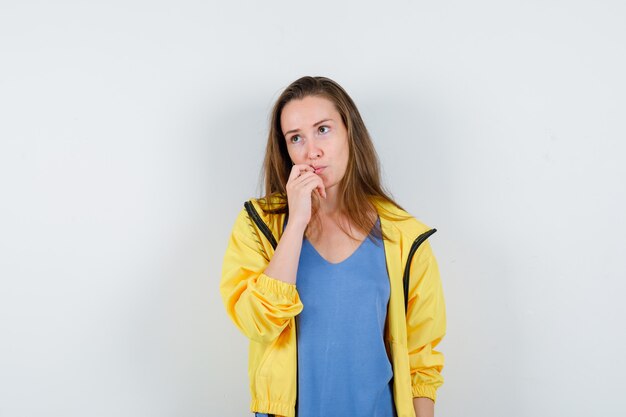 Young lady holding hand on chin and looking pensive