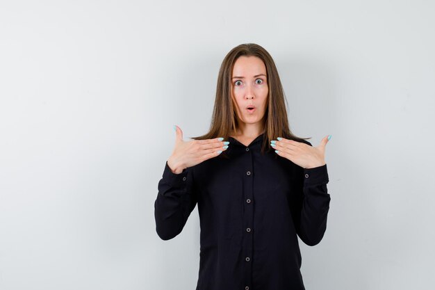 Young lady holding hands on chest and looking shocked