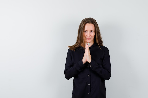 Young lady holding hands in praying gesture