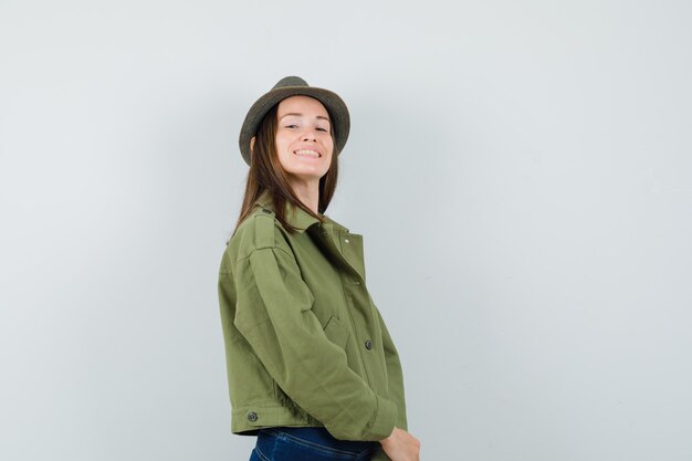 Young lady in jacket pants hat looking at camera and looking stunning 