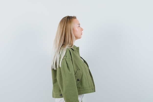 Free photo young lady in jacket, pants looking away and looking focused .