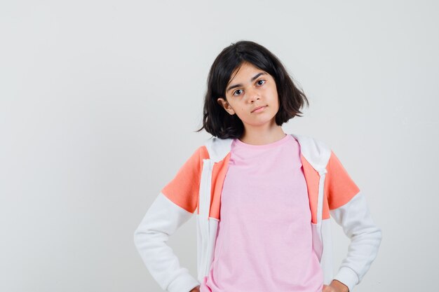 Young lady in jacket, pink shirt and looking serious.