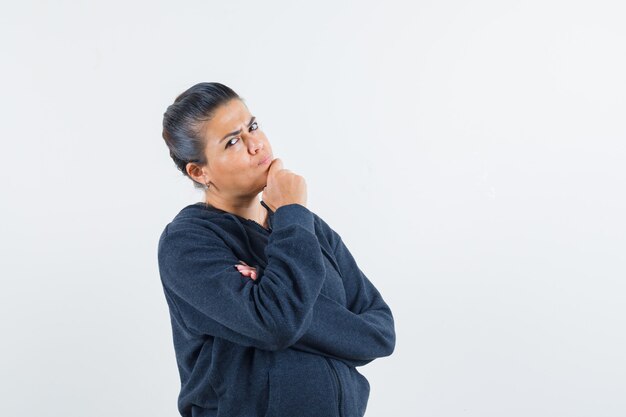 Free photo young lady in jacket thinking something with hand on chin and looking concentrated