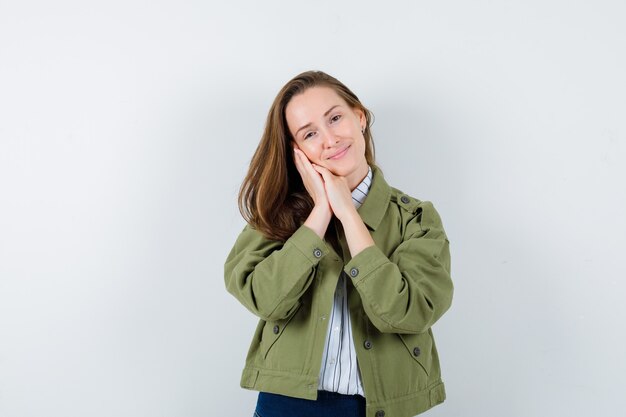 Young lady leaning on palms as pillow in shirt, jacket and looking cute, front view.