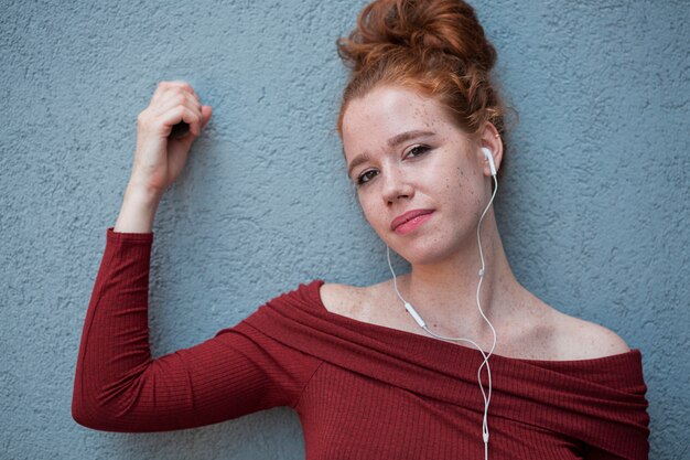 Young lady listening to music and looking at camera