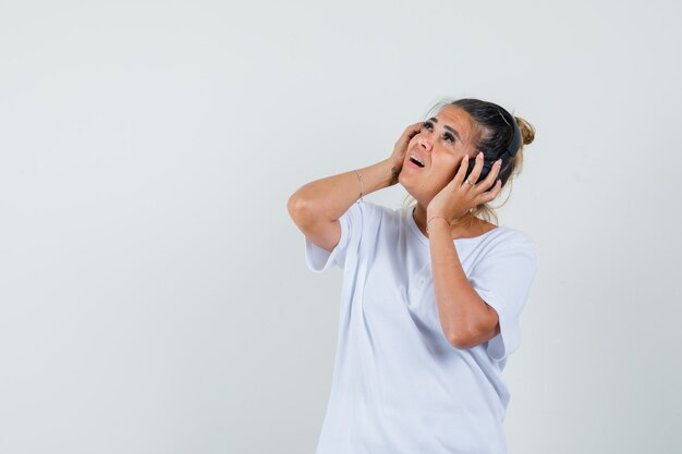 Young lady listening to music with headphones in t-shirt 