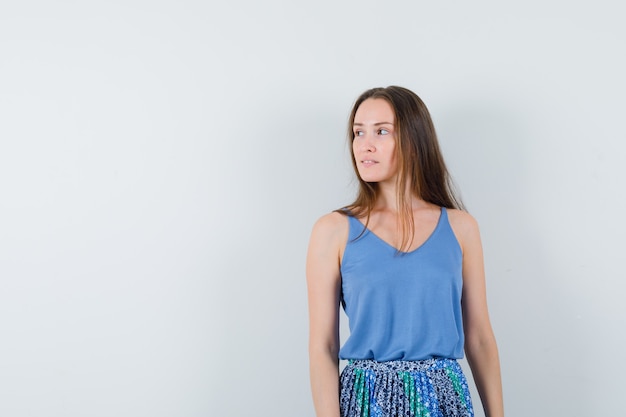 Free photo young lady looking aside in blouse,skirt , front view. space for text