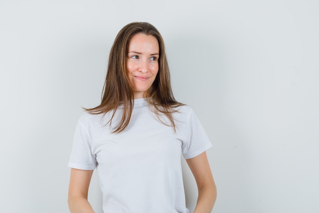 Young lady looking away in white t-shirt and looking merry  