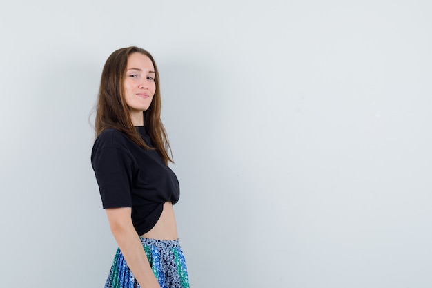 Young lady looking at camera in blouse, skirt and looking elegant .