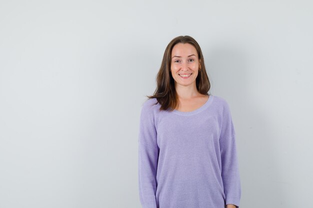 Young lady looking at camera in casual shirt and looking cheerful. front view.