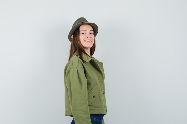 Young lady looking at camera in jacket pants hat and looking charming 