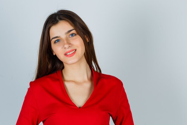 Young lady looking at camera in red blouse and looking alluring