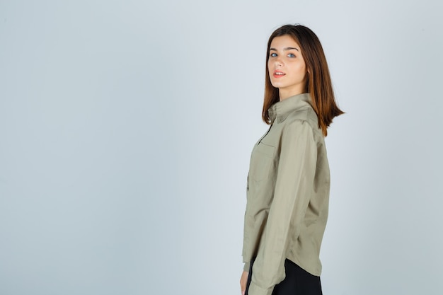 Young lady looking at camera in shirt, skirt and looking cheerful .