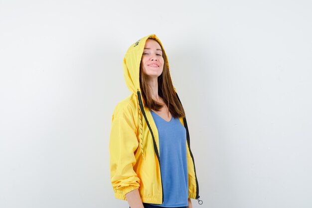 Young lady looking at camera in t-shirt, jacket and looking proud.