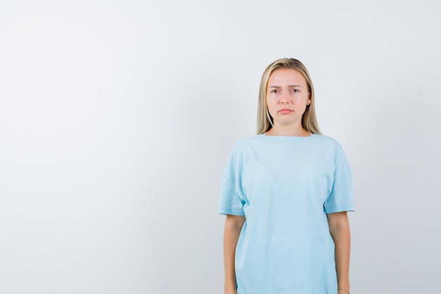 Young lady looking at camera in t-shirt and looking offended isolated