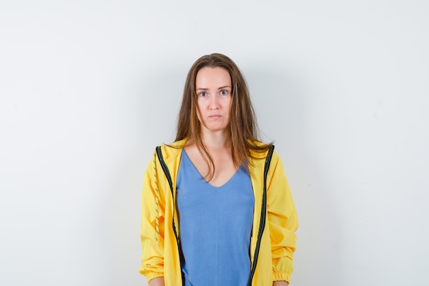 Young lady looking at camera in t-shirt and looking serious. front view.