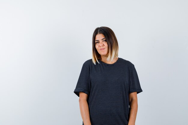 Young lady looking at camera while posing in polo dress and looking pretty. front view.