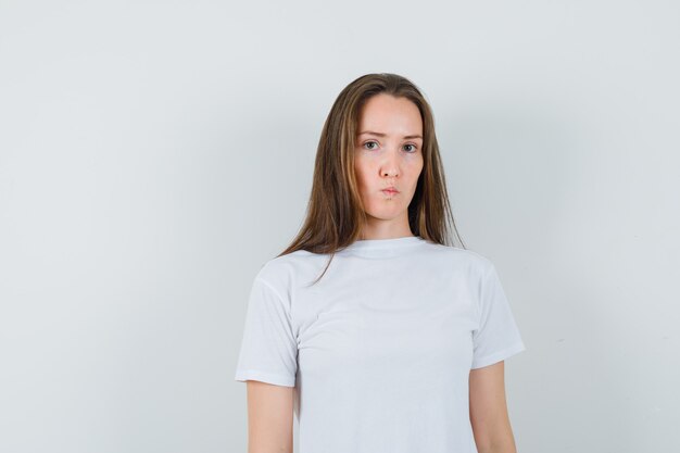 白いTシャツでカメラを見て、真剣に見える若い女性