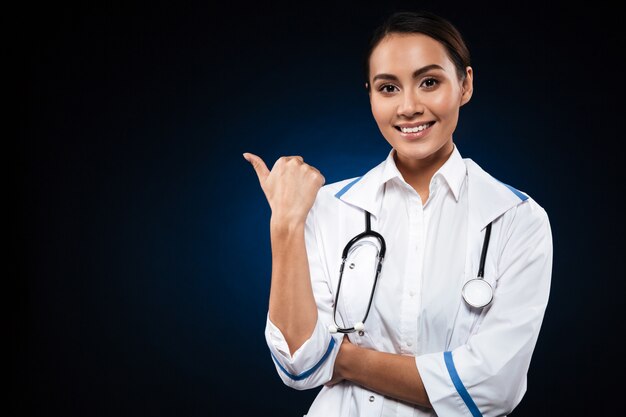 Young lady looking and pointing at copy space