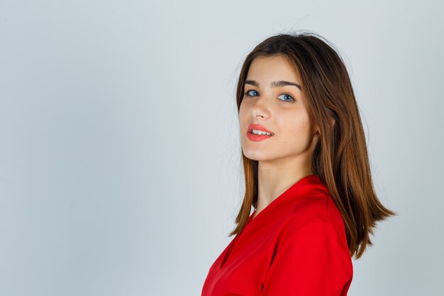 Young lady looking over shoulder in red blouse and looking charming