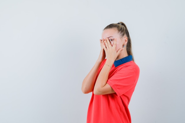 Tシャツで指を見て、落ち着いて見える若い女性