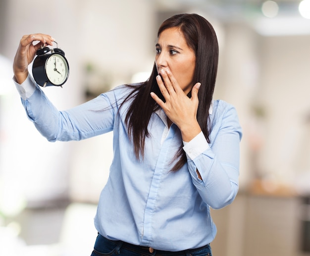 Free photo young lady looking at the time and covering her mouth