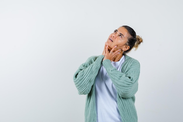 Young lady looking up in t-shirt, jacket and looking thoughtful