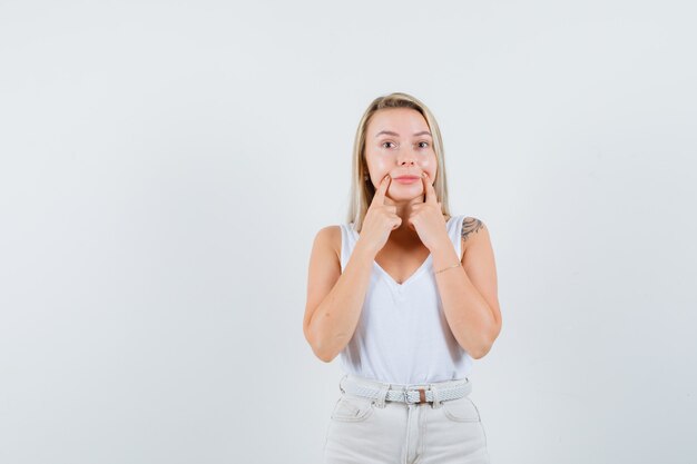 Young lady making fake smile in white blous