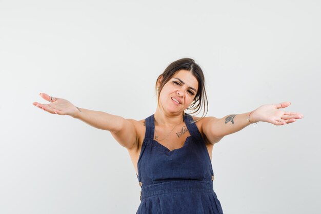 Young lady opening arms for hug in dress and looking kind