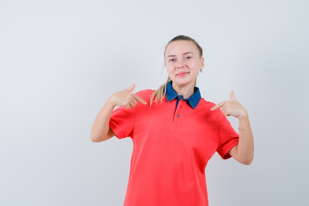 Young lady pointing at herself in t-shirt and looking proud