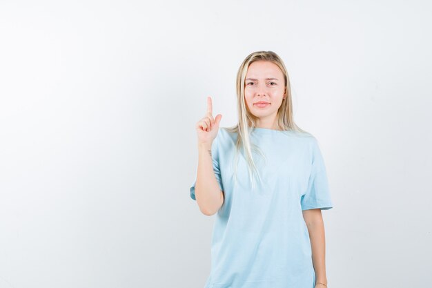 Tシャツを着て、自信を持って見ている若い女性。正面図。