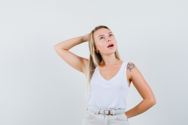 Young lady posing at camera in white blouse and looking impressive