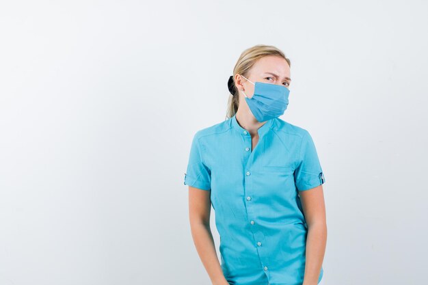 Young lady posing in t-shirt, mask and looking careful