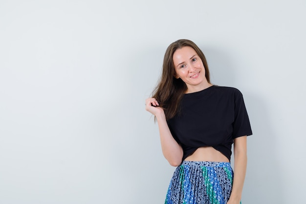 Free photo young lady posing while standing in blouse, skirt and looking cute