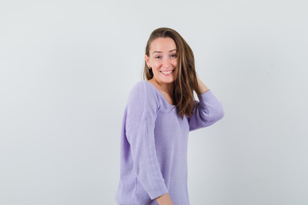 Young lady posing while standing in casual shirt and looking elegant. front view.