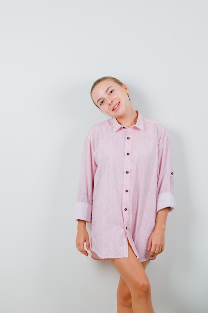 Free photo young lady posing while standing in pink shirt and looking lovely