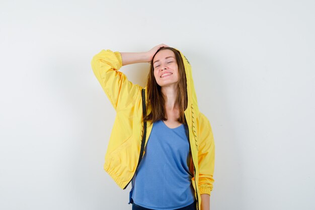 Young lady posing with hand on head and looking hopeful. front view.