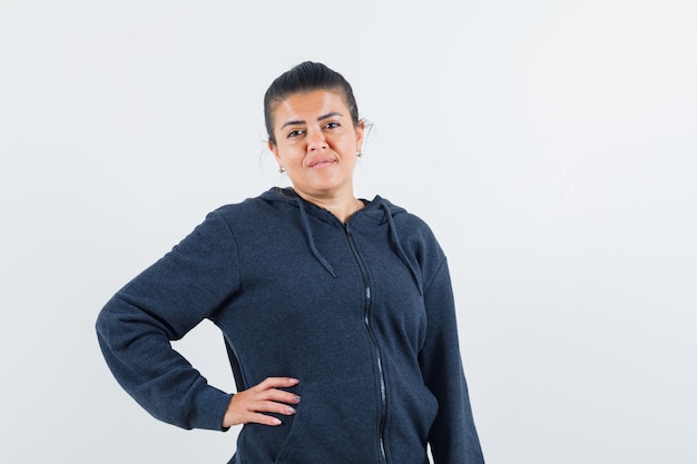 Young lady posing with hand on waist in jacket 