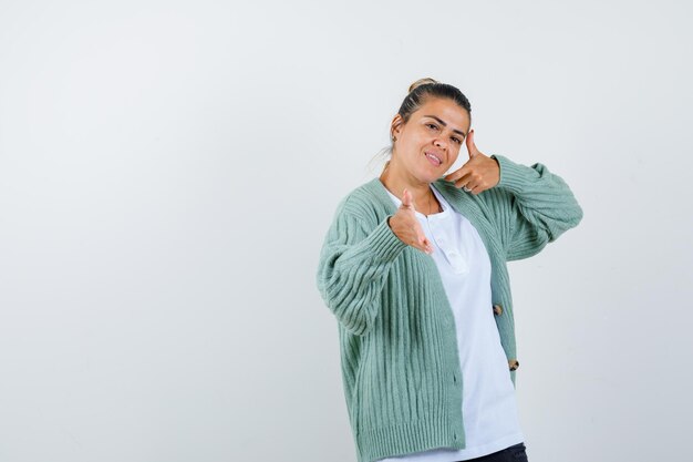 Young lady pretending to show something in t-shirt, jacket and looking pretty