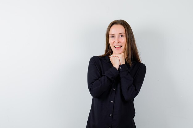 Young lady propping chin on clasped hands