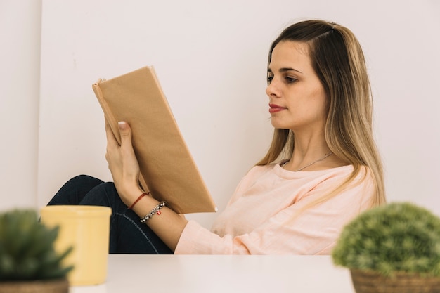 テーブルの近くの若い女性の読書