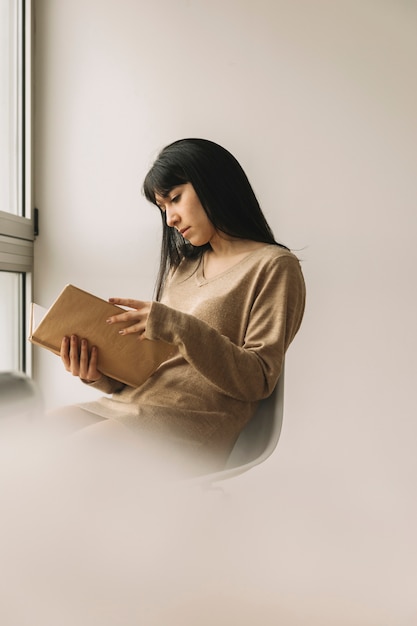 Foto gratuita giovane donna che legge in mattinata