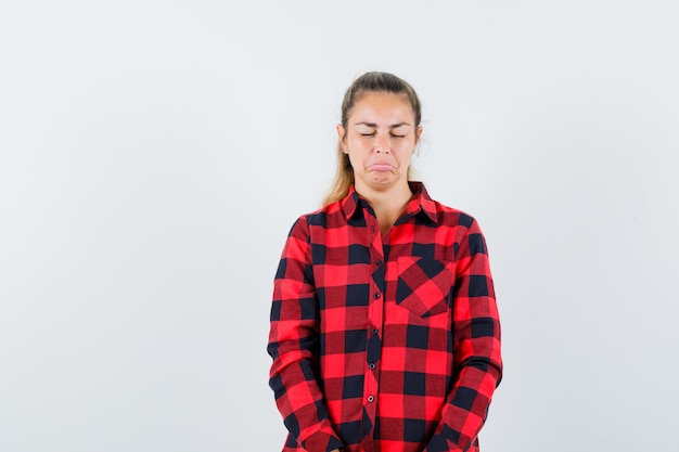 Young lady scowling her face in casual shirt and looking offended. front view.