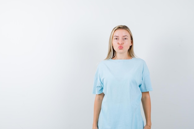 Free photo young lady sending kiss with pouting lips in t-shirt and looking cute