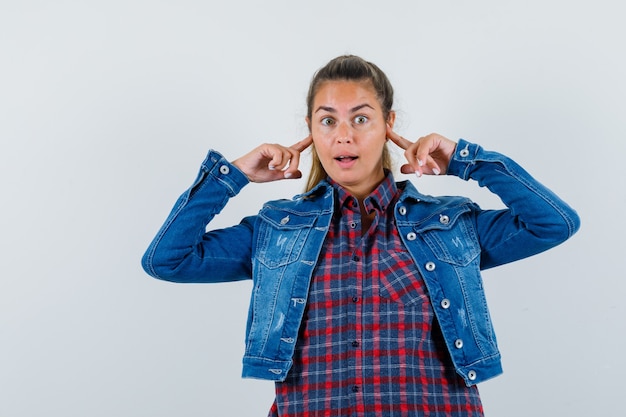 Free photo young lady in shirt, jacket holding fingers on head and looking puzzled , front view.