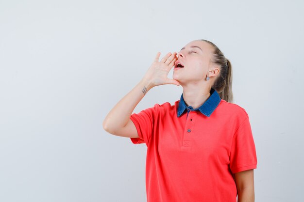 Young lady shouting or announcing something in t-shirt and looking relaxed