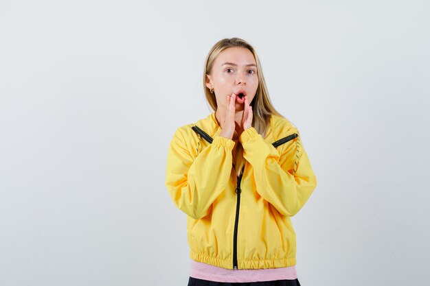 Young lady shouting something in t-shirt, jacket and looking confident