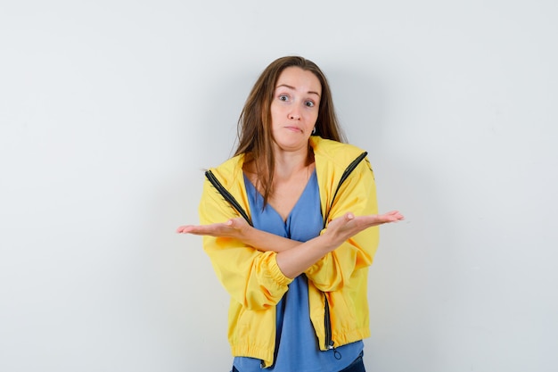 Free photo young lady showing both sides by shrugging in t-shirt and looking confused , front view.