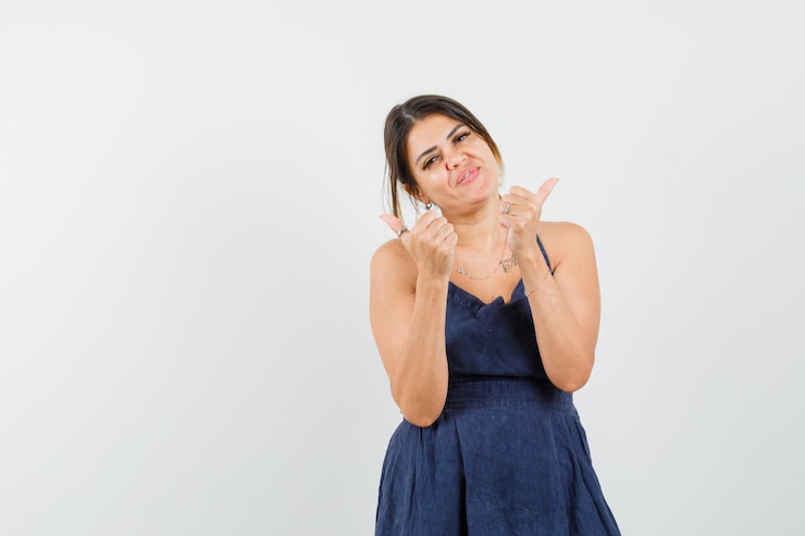 मुफ़्त फोटो young lady showing double thumbs up in dress and looking merry